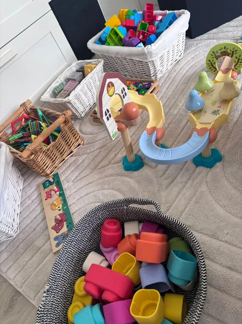 Baskets of building blocks and toys arranged on a rug